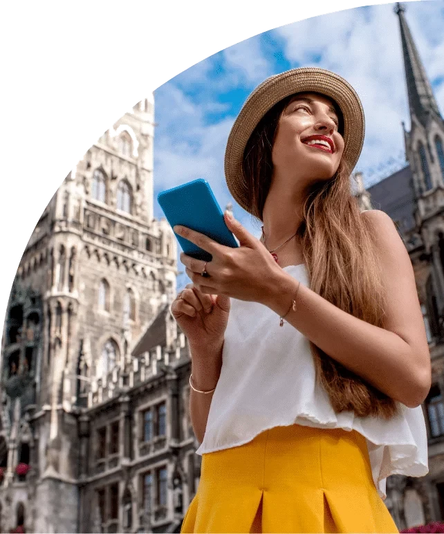 A smiling traveller reads an email on her phone during her stay.